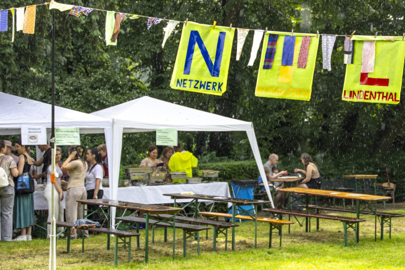 NIL-Fest 2025: Wimpel und Pavillons und essende Menschen im Regen